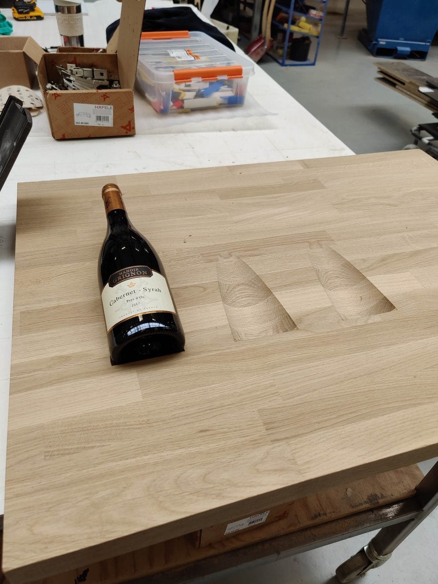 CNC-routed wine bottle slot in oak tabletop